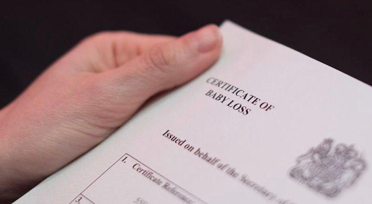 Image of hands holding a baby loss certificate.