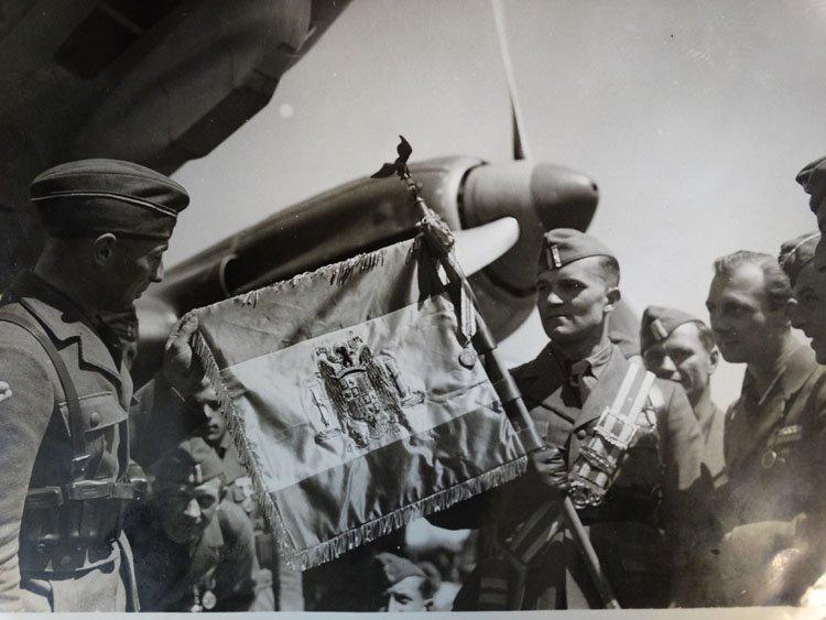 The flag of the Condor Legion - with similarities to the flag of Franco's Spain - is held by troops at an airfield