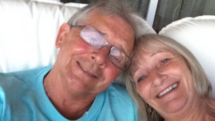 Lorraine and Graham are smiling at the camera. Graham has grey hair and glasses, and Lorraine has short blonde hair