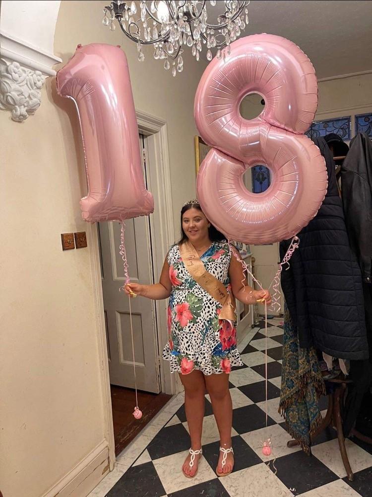 Clodagh O'Brien holds 18 balloons