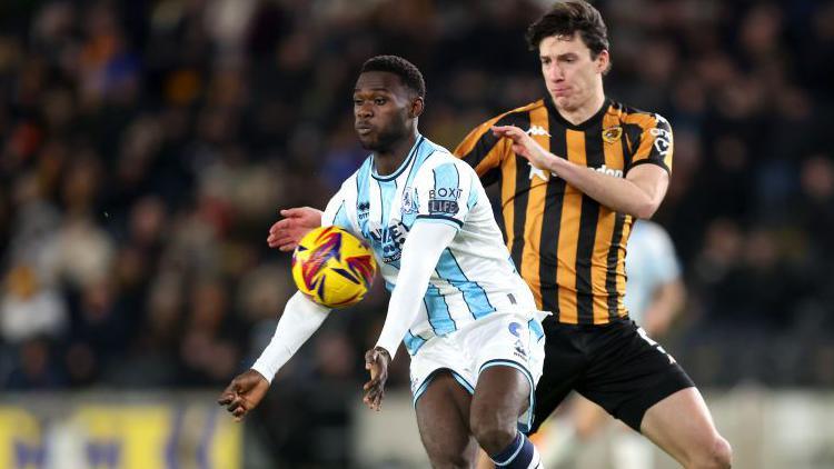 Emmanuel Latte Lath of Middlesbrough controls the ball whilst under pressure from Alfie Jones of Hull City 