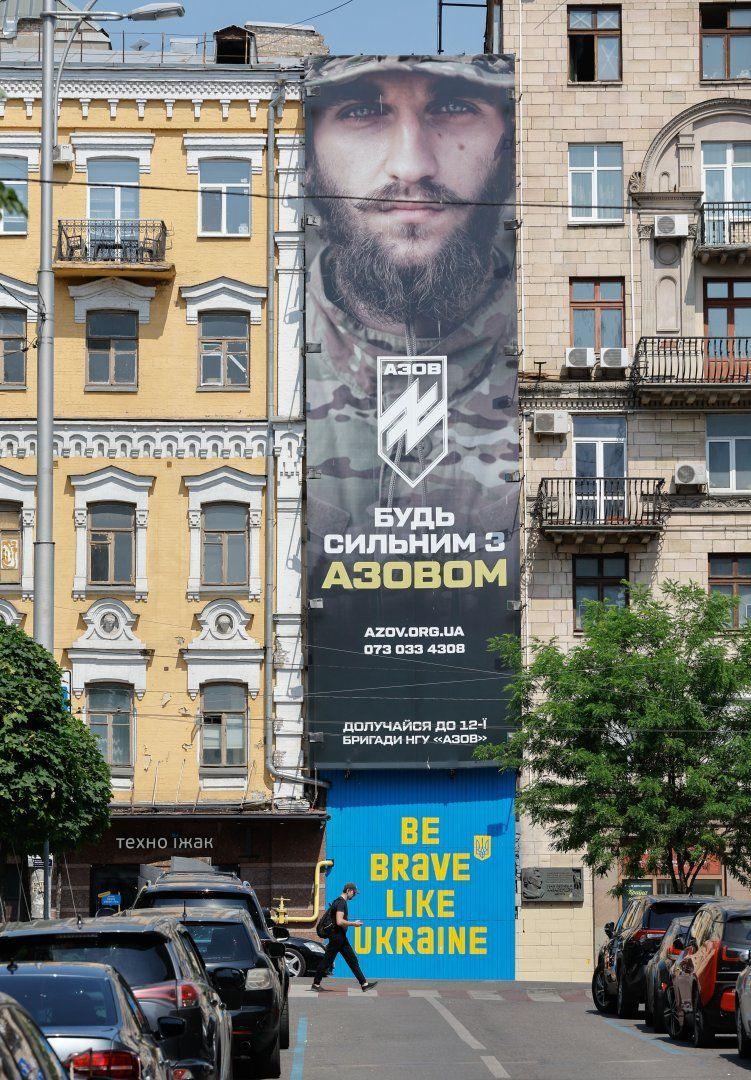 People walk past a recruiting poster of the Azov brigade in Kyiv, Ukraine. Photo: May 2024