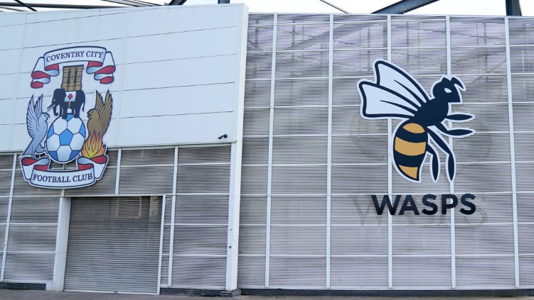 Crests of Coventry City Football Club and Wasps are displayed on the side of the Arena building.