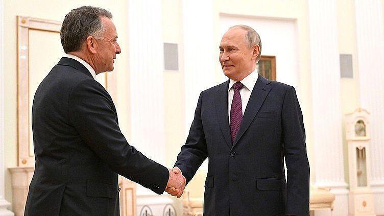 Two men in dark suits, Putin on the right, shake hands in the Kremlin in Moscow in April