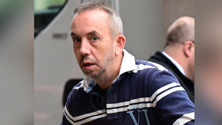 A man with a blue and white striped top, with short greying hair and a grey beard.