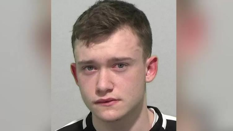 A mug shot of a young man with short brown hair.