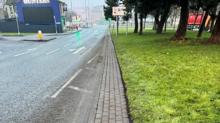 A main road into Bradford with a neatly trimmed grass verge on the right-hand side.