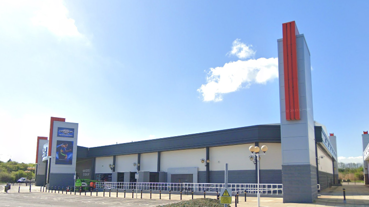 A Google Streetview screenshot of the former Rainbow Casino unit at Teesside Park. The single-storey block is painted in cream, with grey detailing and doors.