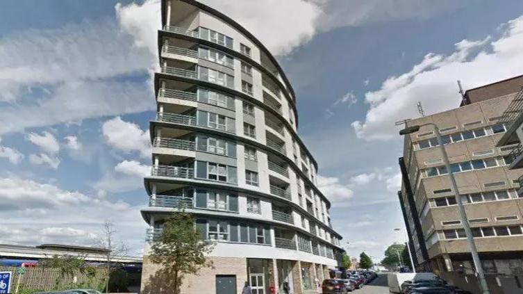 Exterior shot of Eastgate House, a nine-storey grey and white tower block in Woking 