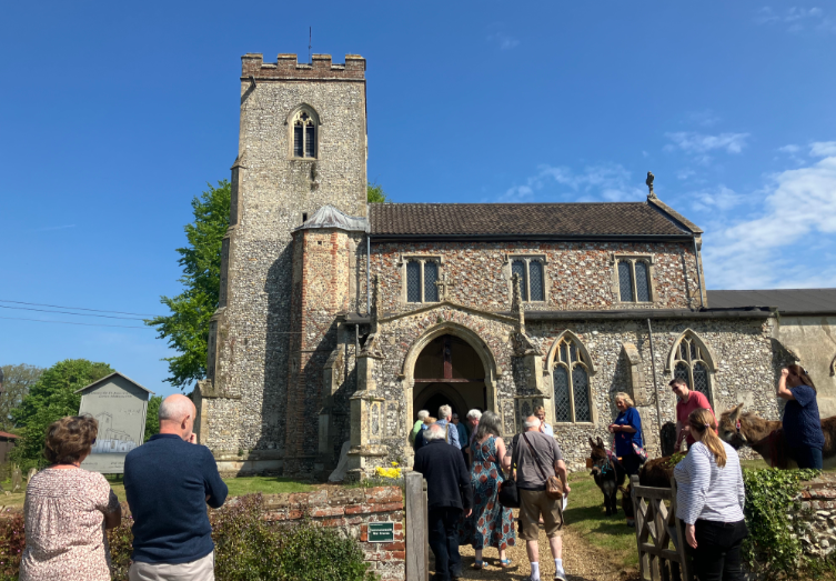 St Andrews Church Little Massingham, with people in foreground en route into the church