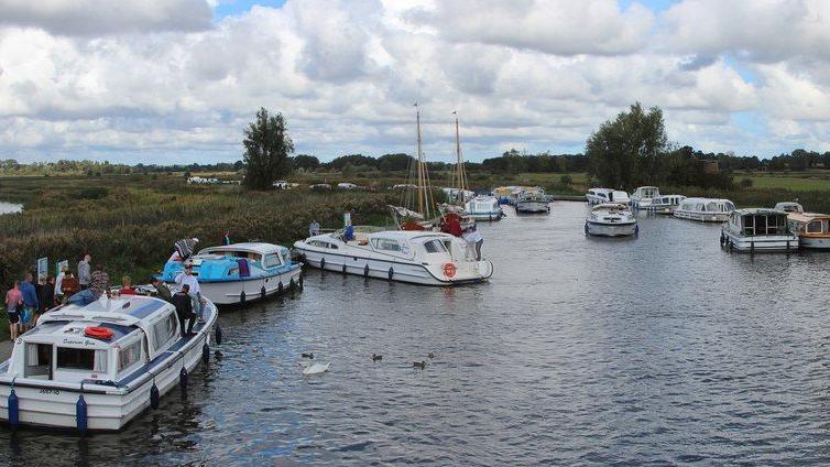 Boats moored and sailing along the River Ant by Ludham Bridge