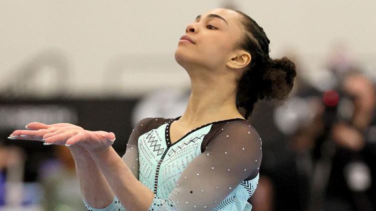 A picture of US gymnast Hezly Rivera wearing a turquiose leotard and performing