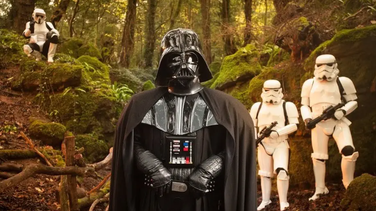 Darth Vader flanked by stormtroopers in a woodland clearing 