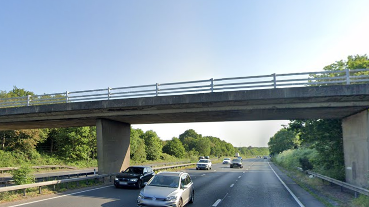 Cars driving on the A3 Ripley bypass near Woking in Surrey on a sunny day.