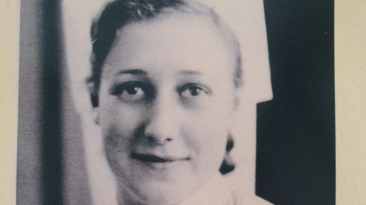 A black and white photo of a woman slightly smiling at the camera with short, dark hair.