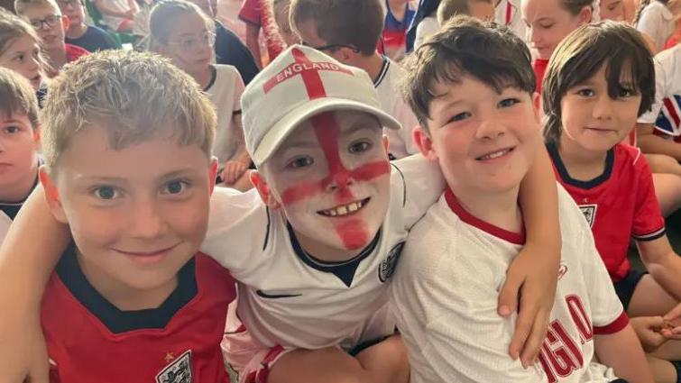 School kids smile watching the game on Monday morning.