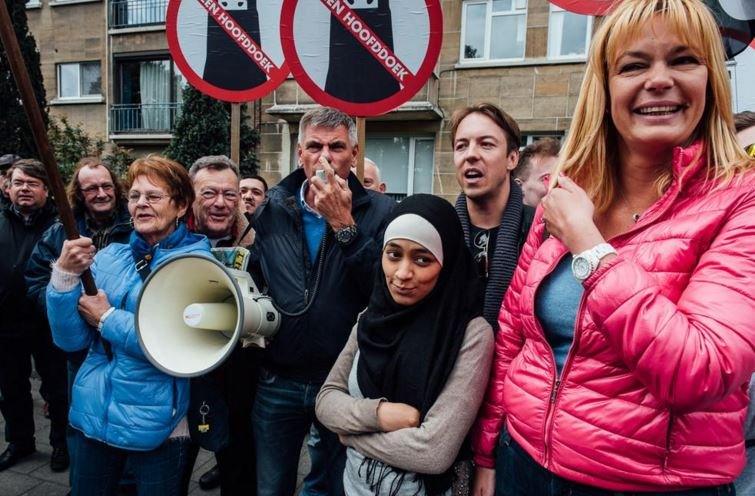 Photo of Zakia Belkhiri standing with protesters from Vlaams Belang