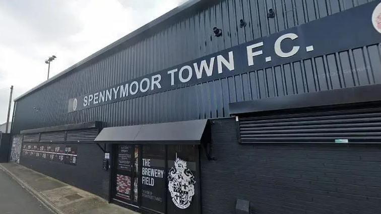 A black metal building with a glass door entrance. A sign on the front of the building reads 'Spennymoor Town FC'