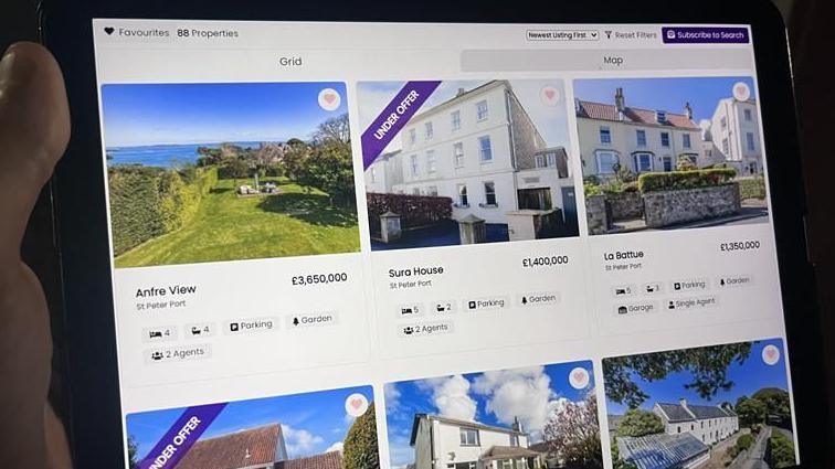 An iPad screen with pictures of houses and house prices on an estate agency website.