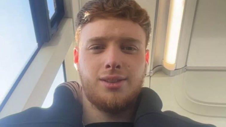 Brandon Kershaw has thick ginger/brown hair shaved down the sides of his head. He also has a beard.