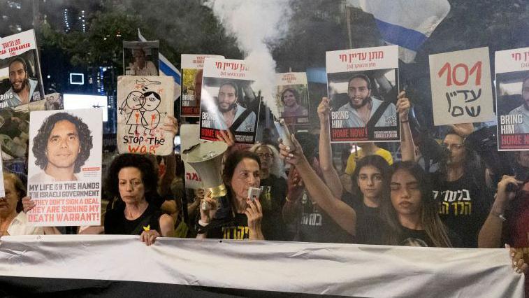 Families and supporters of hostages held in the Gaza Strip hold signs during a demonstration calling for an hostages deal on October 17, 2024 in Tel Aviv, Israel