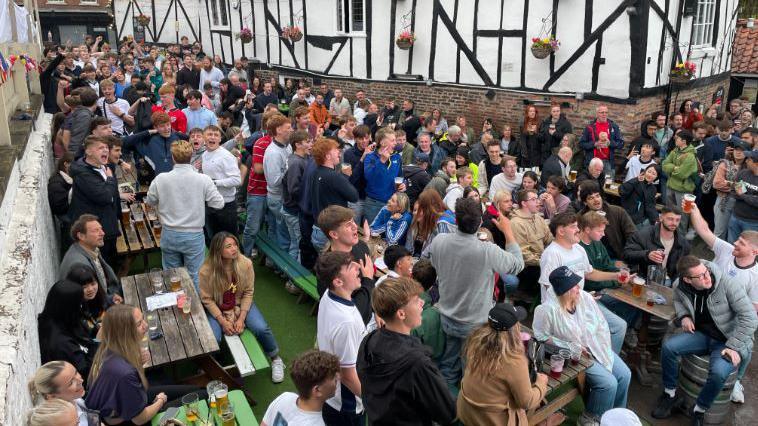 Fans stand for the national anthem at the Red LIon in York