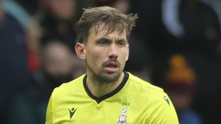 Sam Walker in a yellow Bradford City goalkeeper jersey during a match