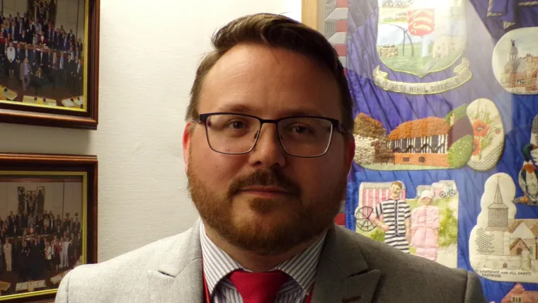 A head-and-shoulders shot of Daniel Cowan, who is wearing a jacket with a shirt and tie.