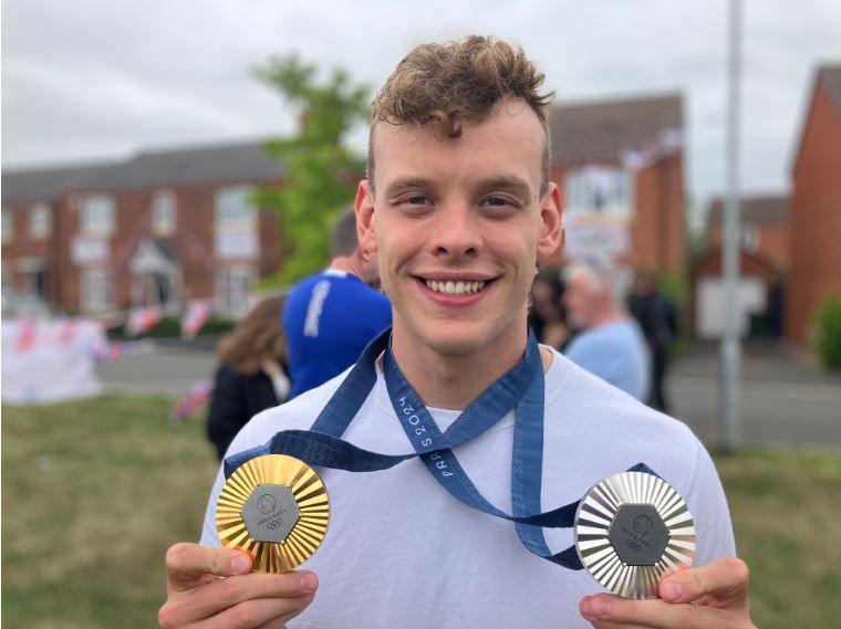 Matt Richards holding a gold and silver medal