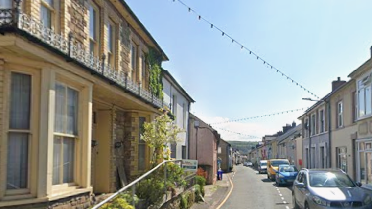 Photo of Hight Street, Llandysul on a sunn day. Cars are parked up the right had side of the road.