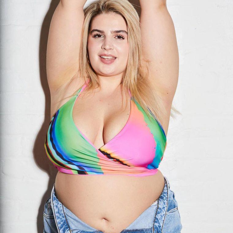 Plus-sized model Enrika poses in a multicoloured top and jeans for a shoot.