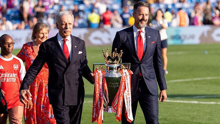 Josh and Stan Kroenke walk trophy out on to pitch