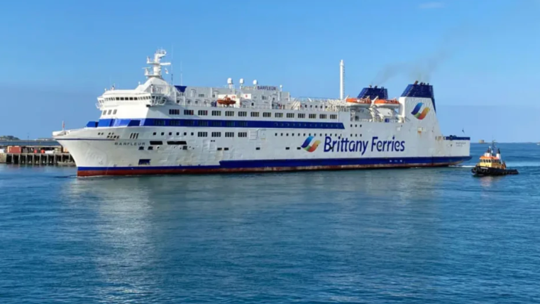 A big white ferry with Brittany Ferries logo on the side, in the ocean.