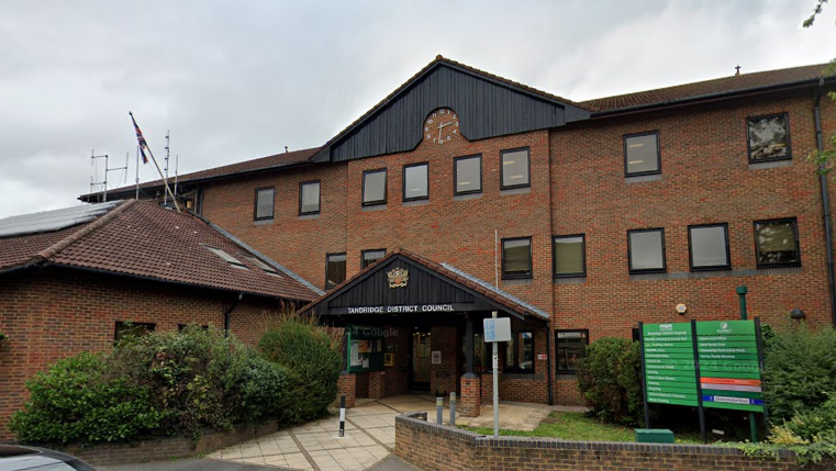 A brown tall building with a sign saying Tandridge District Council above the entrance