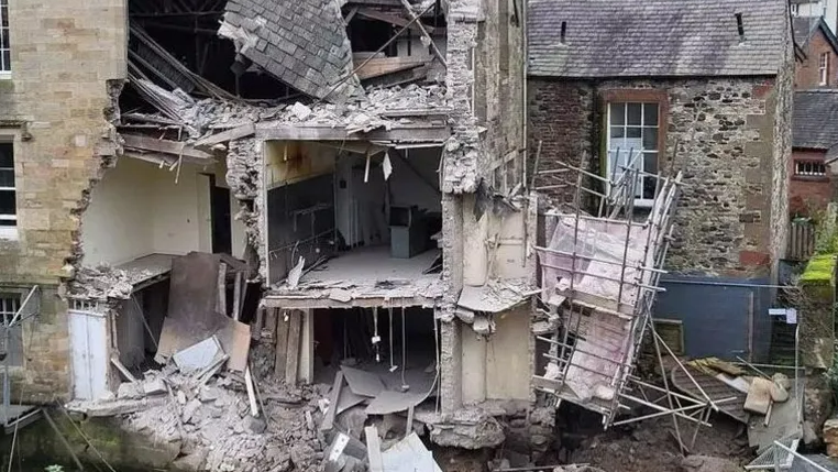 Collapsed courthouse building with walls missing allowing a view into interior rooms