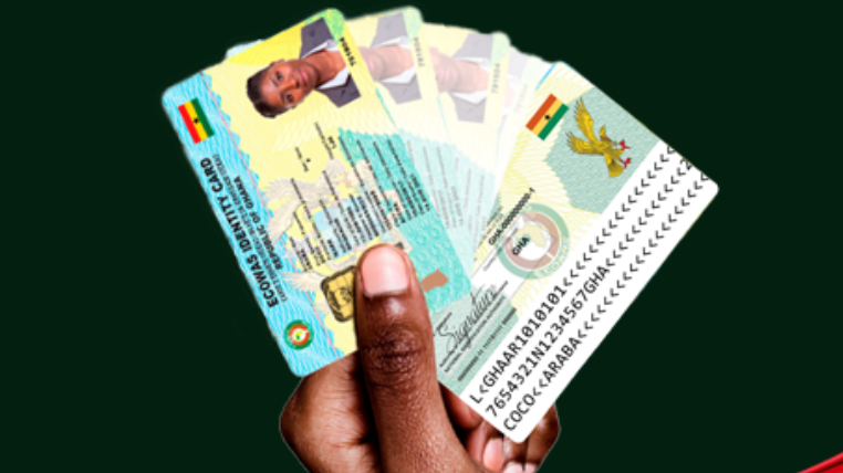 A hand fans out several Ghana Cards, showing the front and back of the national identity card 