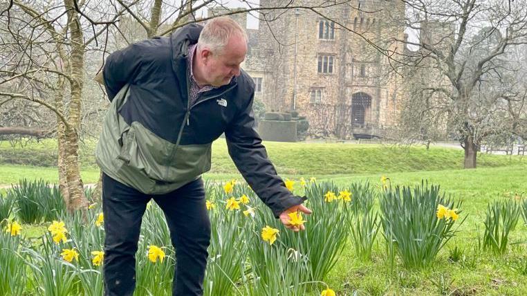 Neil Miller and daffodils, with Hever Castle in the background