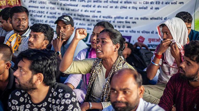 Group of people sitting on the flood, chanting slogans during a protest in India's Jharkhand state