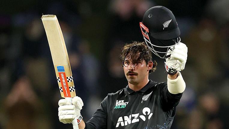Tim Robinson raises his bat and helmet after reaching his century