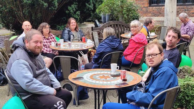 People sitting at tables outside Christchurch Mansion, Ipswich