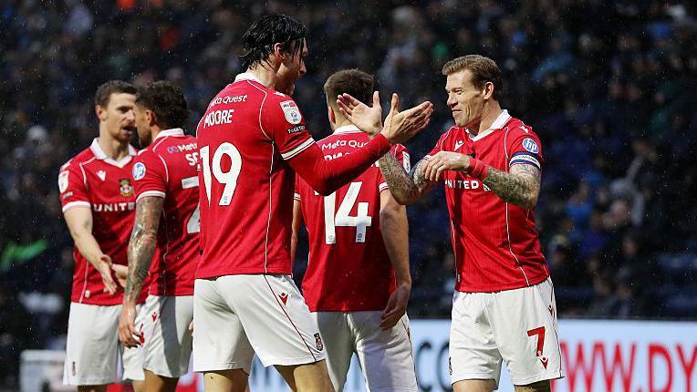 Wrexham striker Kieffer Moore (centre) celebrates with James McClean (right)