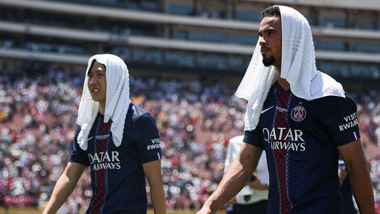 PSG duo Lee Kang-in and Warren Zaire-Emery with a towel on their head to try and cool them down after the Club World Cup encounter with Atletico Madrid