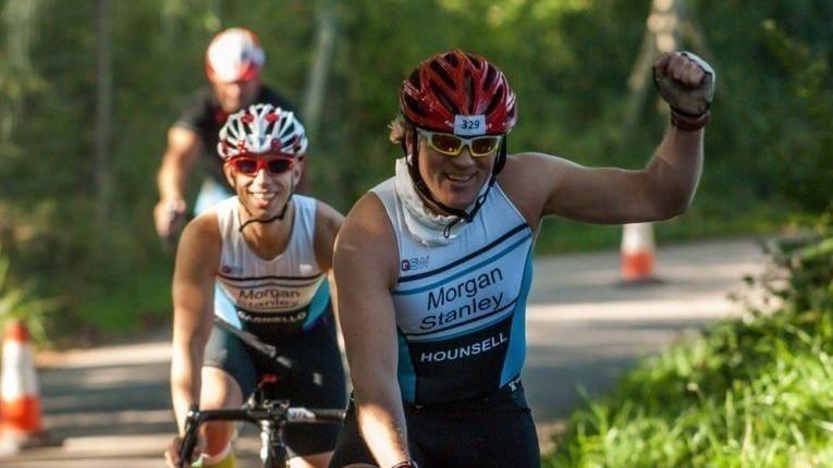 Two triathletes finishing the cycle section of a triathlon.