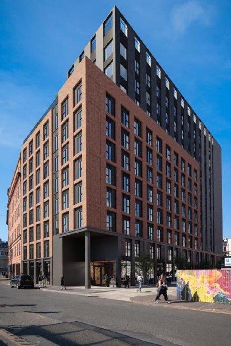 Student accomodation development beside road made out of grey and red brick.