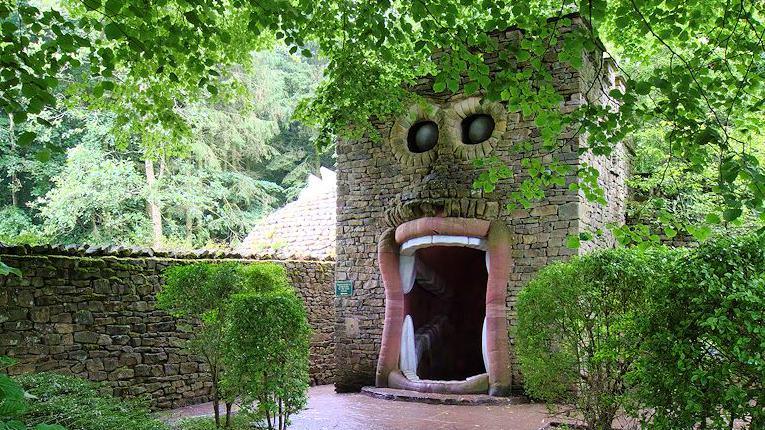 A stone building with a doorway and windows designed to look like eyes and a gaping mouth.