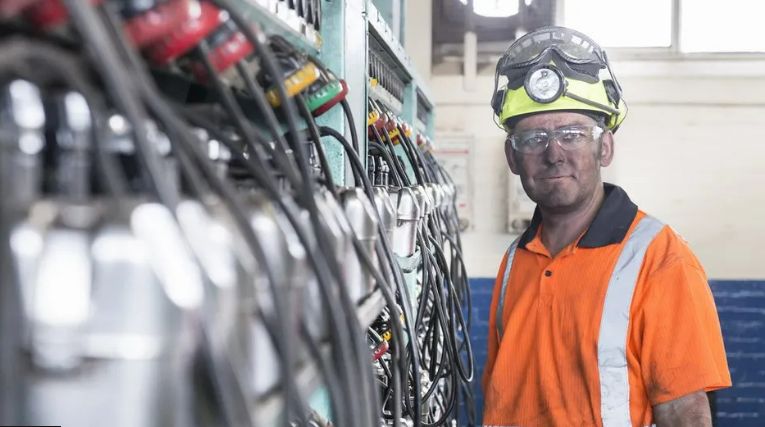 A miner in front of some equipment 