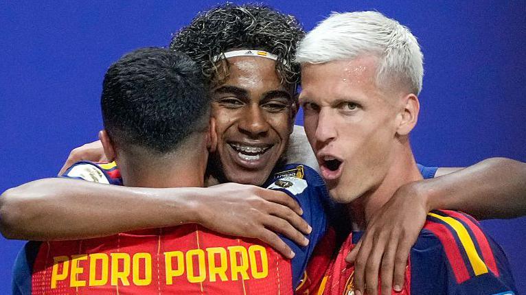 Spain's Lamine Yamal celebrates with Pedro Porro and Dani Olmo