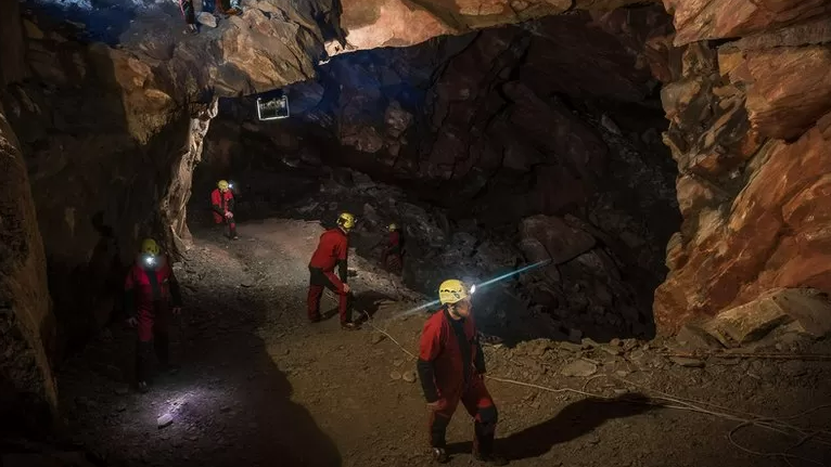 Three men in a cave