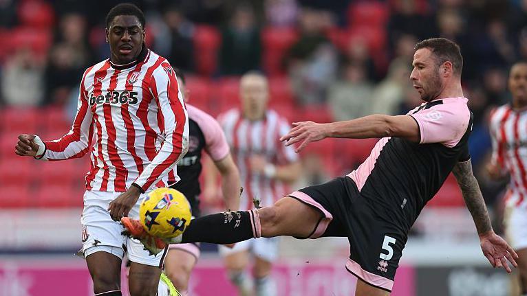 Stoke City forward Divin Mubama and Queens Park Rangers defender Steve Cook contest the ball