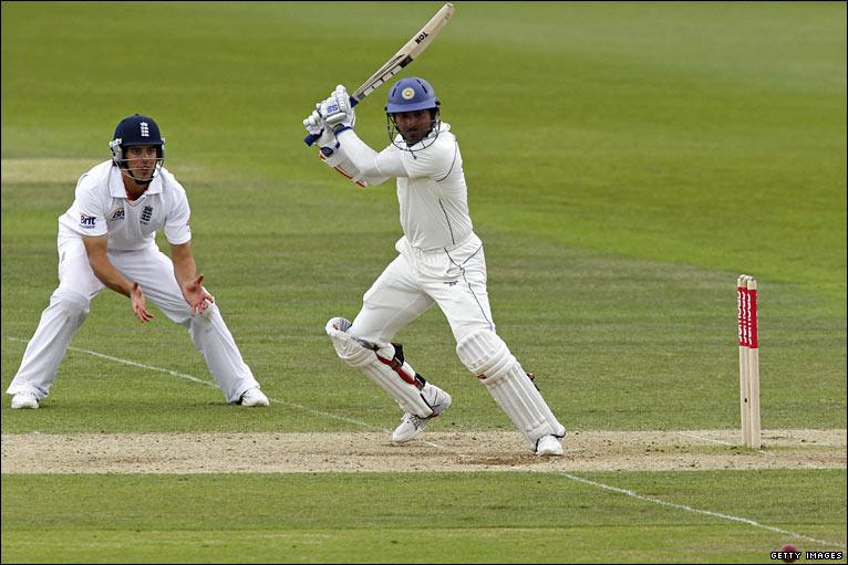 Alastair Cook looks on Kumar Sangakkara plays a shot for Sri Lanka